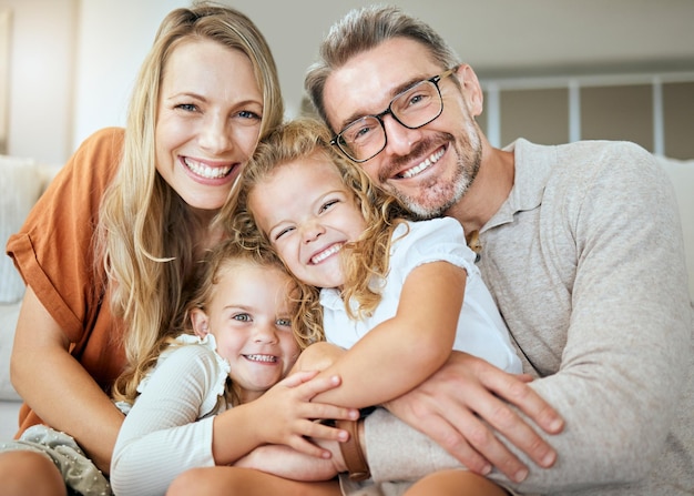 Photo parents portrait and sofa with hug kids and smile with love bonding and care in family home together father mother and daughters with happiness embrace and relax on lounge couch in house