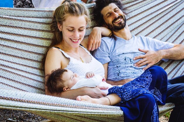 Parents relaxing with baby on hammock