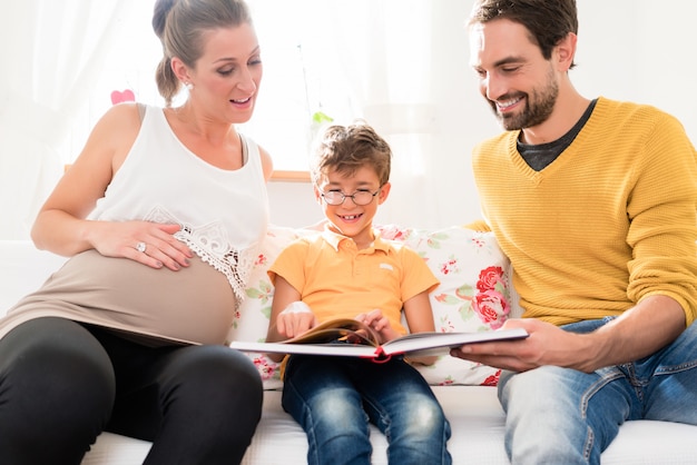 Parents showing their firstborn son pictures in family album