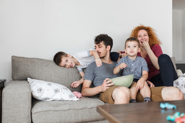 Photo parents sitting with their children watching television