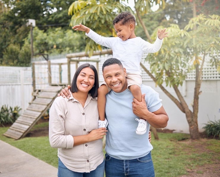 Photo parents smile and child on shoulders outdoor with hug for game family bonding and support of love in backyard happy woman and man with boy for trust security and care together in nature