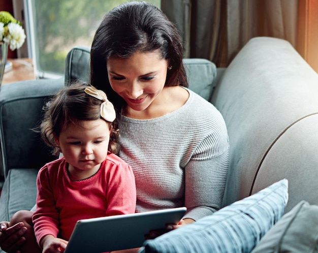 parents sofa and mother with baby on tablet for online games watching videos or streaming subscription family home and mom with young girl on digital tech for cartoons bonding and relax together