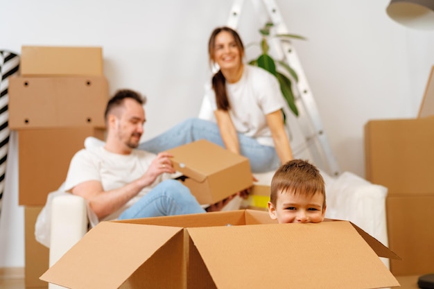 Parents and son packing boxes and moving into a new home