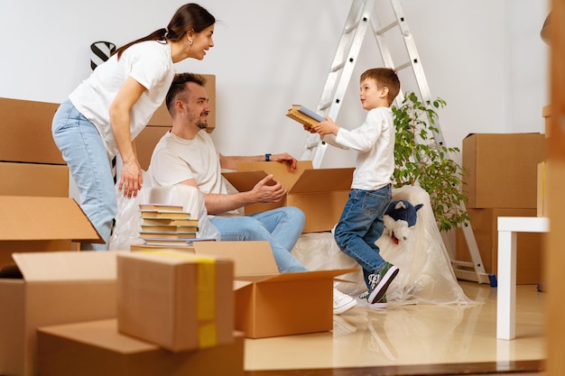 Parents and son packing boxes and moving into a new home