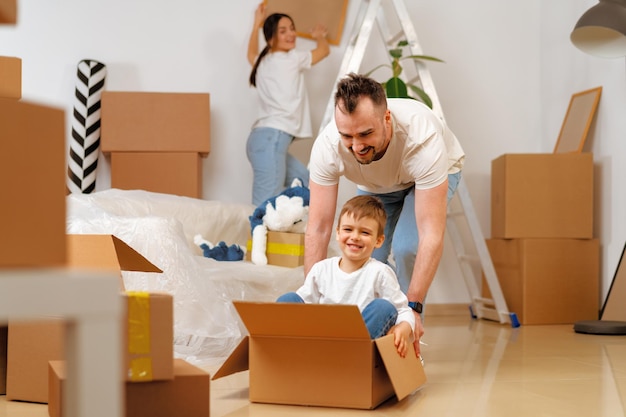 Parents and son packing boxes and moving into a new home