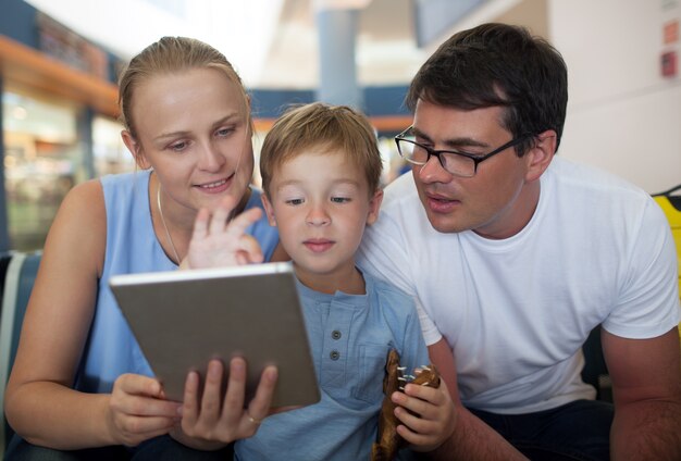 Genitori e figlio con tablet pc in aeroporto