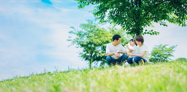 화창한 녹색 공간에 앉아 있는 부모와 자녀