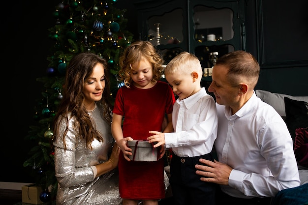 親と子供のプレゼント交換 メリー クリスマスとハッピー ホリデー