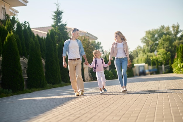 Parents and their daughter walking and holding hands