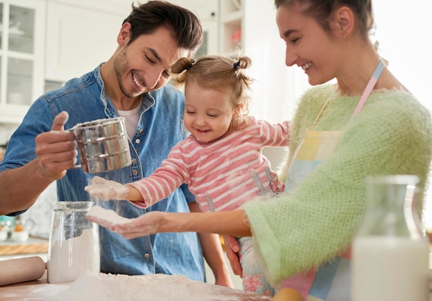 Photo parents and their little girls in the kitchen