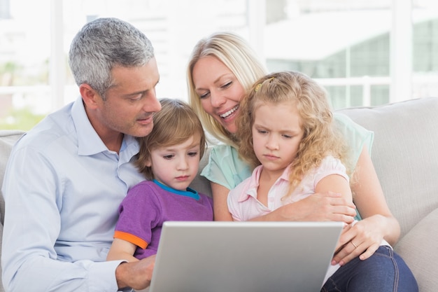 Photo parents using laptop with children