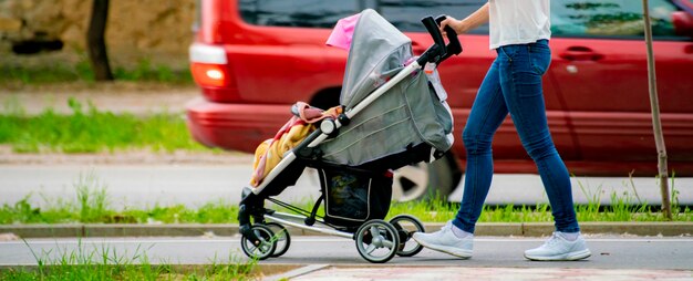 写真 街の通りの公共公園の路地を屋外で歩く乳母車を持つ親