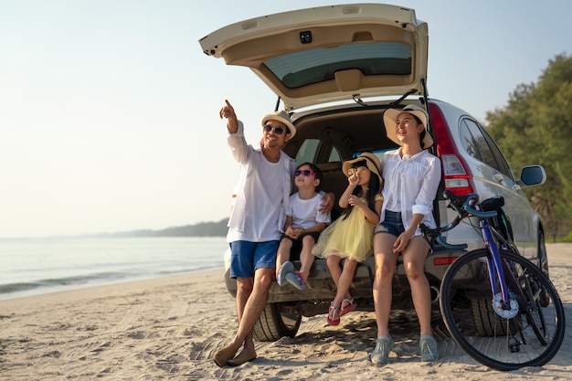 Photo parents with children enjoying vacation on beach