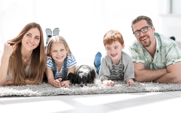 Photo parents with children lying in the living room on the carpetphoto with copy space