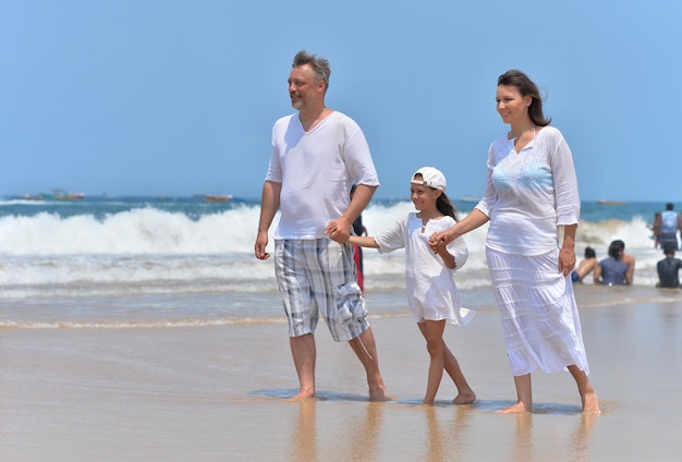 Parents with daughter walking on beach