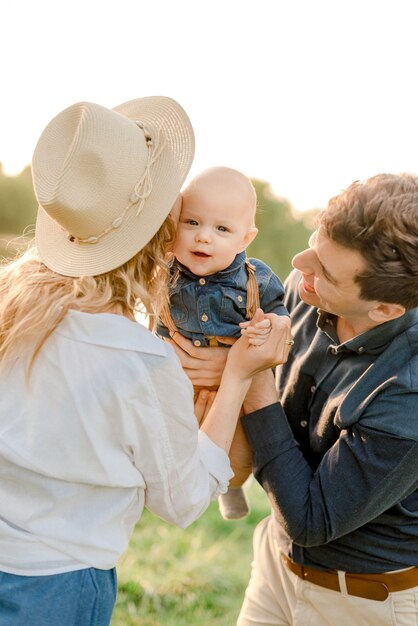 Photo parents with their kid in the park