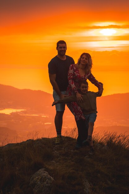 Genitori con il figlio in cima a una montagna al tramonto