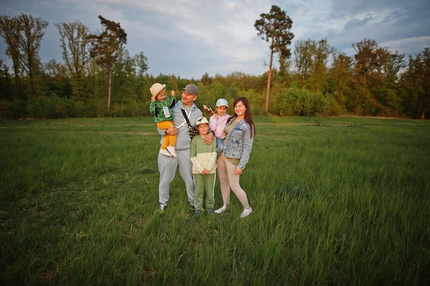 Parents with three kids having fun together at meadow