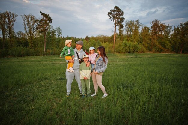 Parents with three kids having fun together at meadow