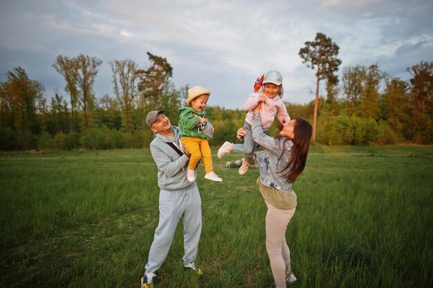 Photo parents with two daughters having fun together at meadow