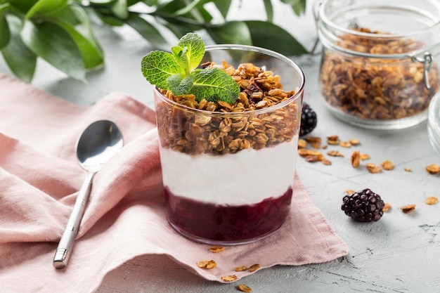 Parfait with yogurt granola jam and fresh berries in the glass jar Healthy dessert or snack