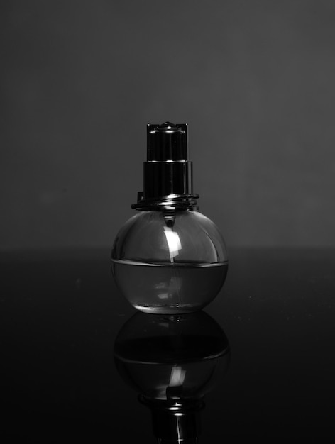 Foto bottiglia di profumo su rosso concetto di aroma bicchiere di profumo cosmetica parfumeria
