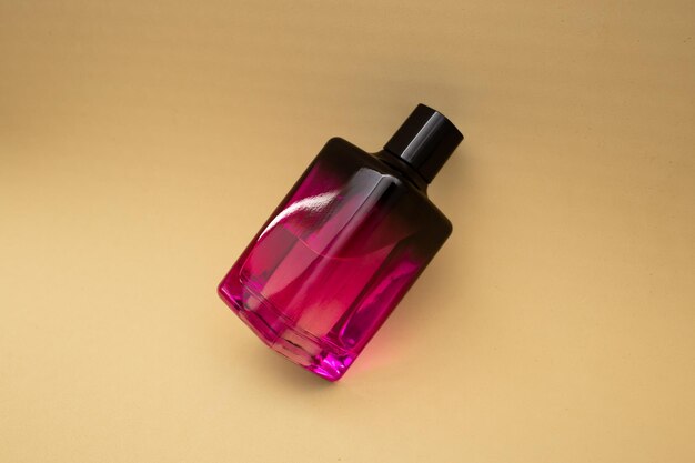 Parfum in een roze fles op een beige achtergrond