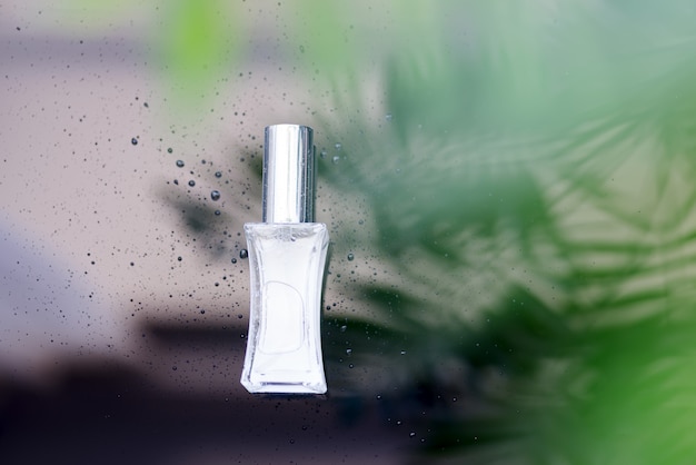 Parfume bottle with green tropical leaves.