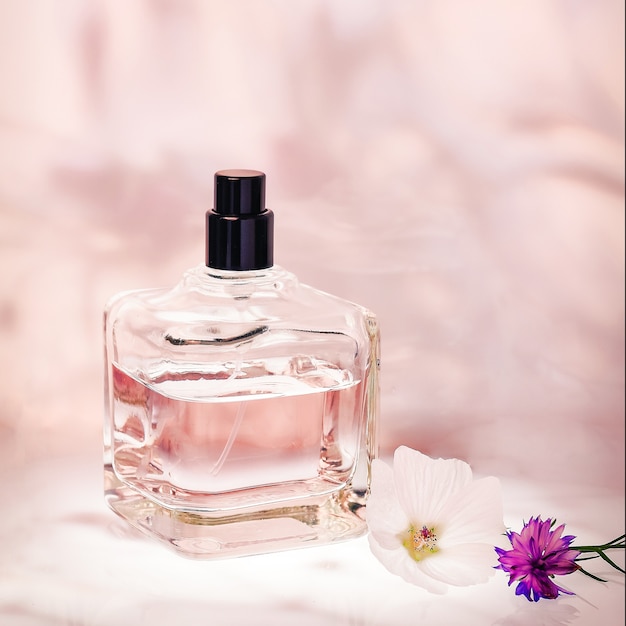 Parfumerieën in een fles met een spuitfles op roze