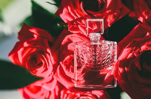 Parfumfles op mooi boeket rozen in zomerparfum als luxe geschenk beauty flatlay backg...