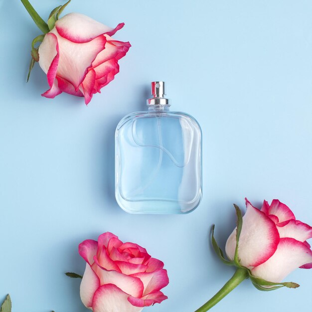 Parfumflesje en rozenbloemen Concept van dure parfum en cosmetica Bloemige geur voor vrouwen Parfumspray