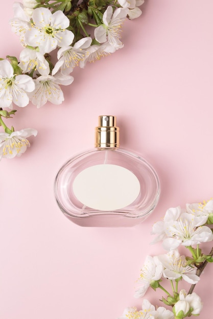 Parfumflesje en tak bloeiende kers Concept van dure parfum en cosmetica Bloemige geur voor vrouwen Parfum spray Moderne luxe dame parfum de toilette