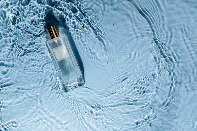 Parfumflesje op blauwe water golvende achtergrond frisse zee geur concept dames en heren essentie