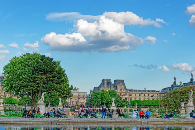 パリ、フランス-2012年5月3日：フランスのパリのルーブル宮殿とチュイルリー庭園でリラックスする人々。現在は博物館になっています。