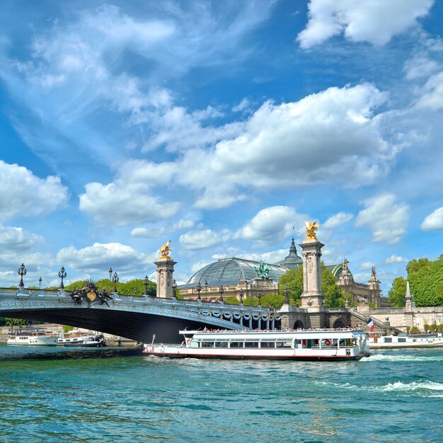 Paris, France, passenger boat passes under Alexander III bridge in Spring.