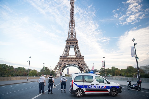 Париж, Франция - 29 сентября 2017: блокпост на фоне эйфелевой башни. Сотрудники полиции и патрульный транспорт. Полицейская машина и мотоцикл. Охранный блокпост. КПП. Город заблокирован.
