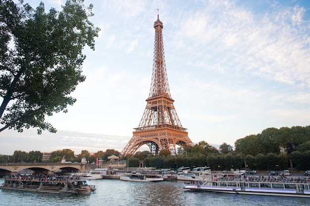 Paris, France - September 29, 2017: Seine river cruises and Eiffel tower. Boat rides. Waterside trips. Sightseeing tour. Landscape and landmarks travel. Traveling and wanderlust. Summer vacation.