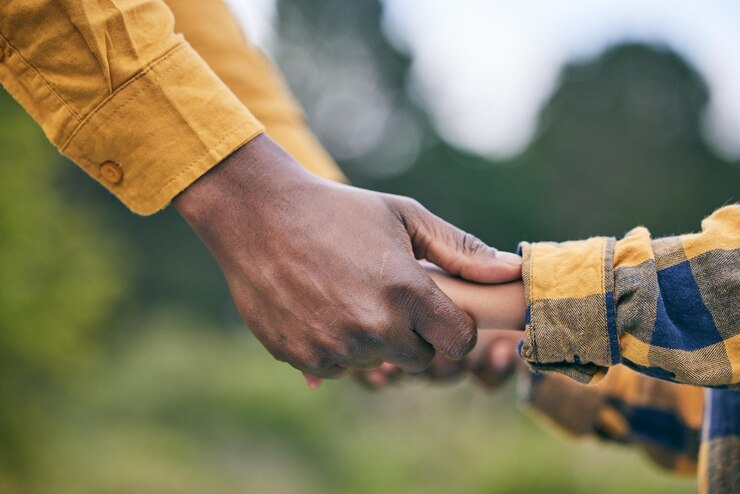 Photo park holding hands and nature child parent or family quality time kindness and care on outdoor adventure wellness or love support relationship and kid freedom connect or closeup people bonding