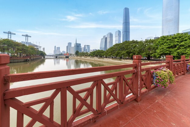 Park red wooden plank road and modern city building in Guangzhou, China