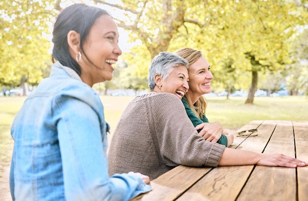 Park senior vrouwen en vrienden lachen om grappige grap gekke meme of komedie Komische blij en groep gepensioneerde vrouwtjes zitten aan tafel met humor hechting praten en genieten van quality time samen