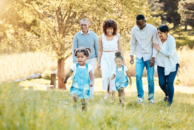 Park walking and happy family generations for bonding having fun and talking together Love smile and children with parents and grandparents in nature in an outdoor green garden on weekend trip