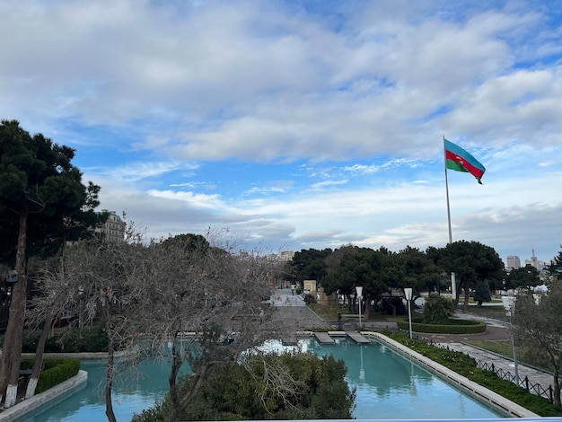 曇りの天候の中でプールとアゼルバイジャンの国旗が揺れる公園