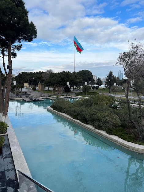 park with pool and azerbaijan flag waving in cloudy weather