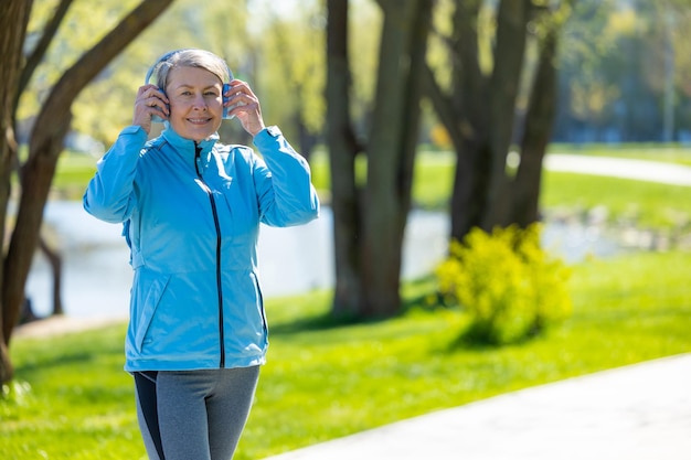 Photo in the park woman in blue blazer in headphones in the park