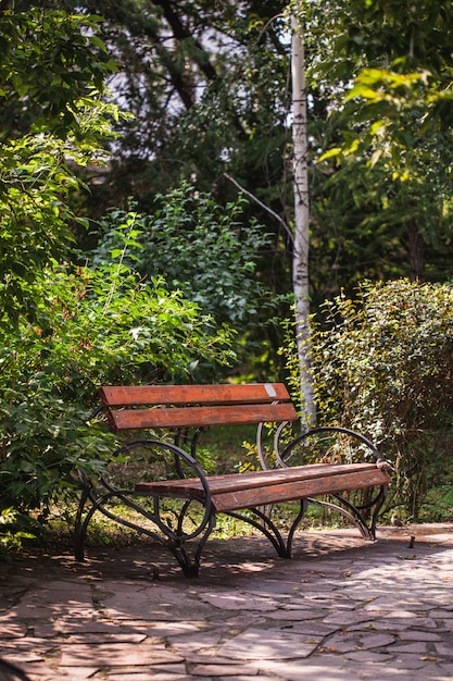 Parkbank, gemaakt van hout en gietijzer, zitten op de bank, zomervakantie