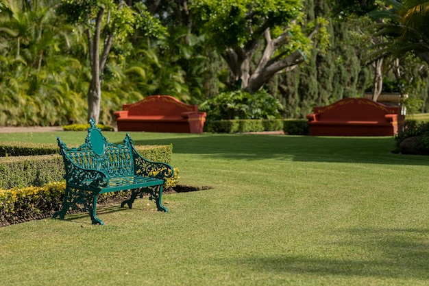 Parkbank om te loungen in een met gras begroeide tuin