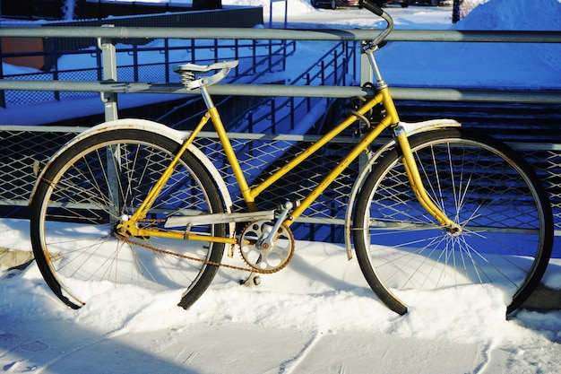 Foto bicicletta parcheggiata nella neve nella stazione foto ravvicinata