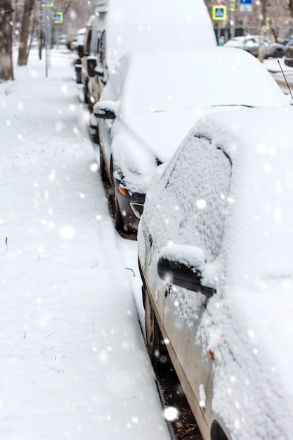 雪の中で駐車した車。冬の都会のシーン