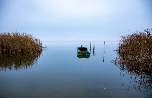 Parked empty fishing boat on the lake before sunrise