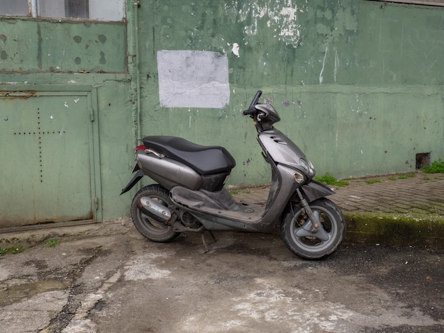 Parked moped Two wheeled vehicle Gray bike urban environment